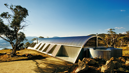 Ground-hugging house in the Snowy Mountains of NSW, with its curved roof of LYSAGHT CUSTOM ORB® is designed to withstand extreme weather. Architect: James Stockwell Architecture.